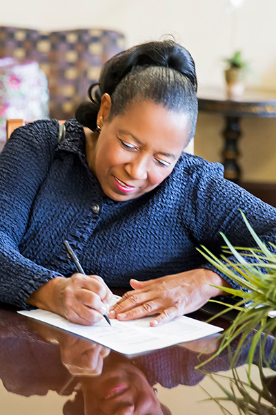 woman sitting at table filling out paperwork