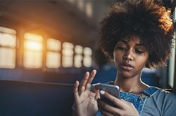 woman looking down at her cell phone