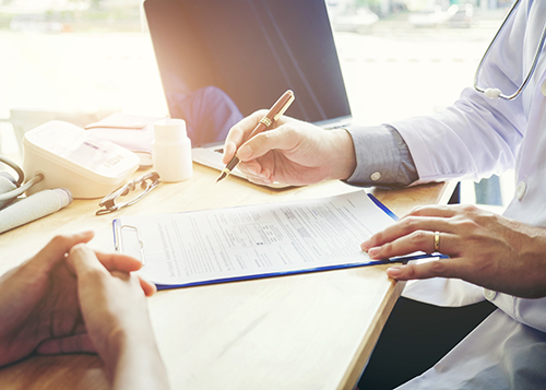 person filling out paperwork at a desk