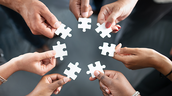 Group of hands with puzzle pieces