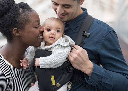 parents smiling and happy looking at baby