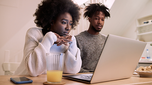 couple sitting down watching something on a laptop