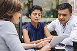 three people talking and looking at paperwork