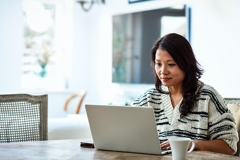 woman sitting at table on her laptop