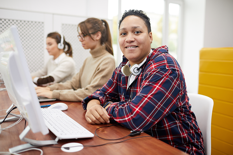 group sitting at table on computers