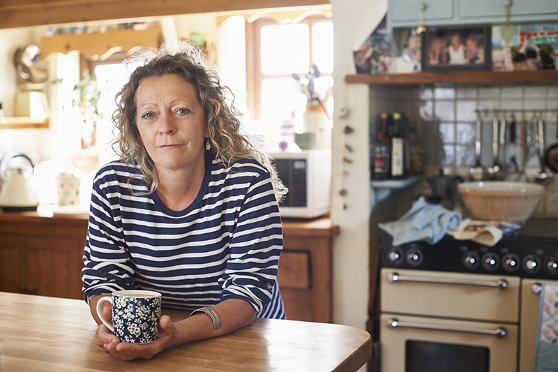 woman sitting at table with a cup of coffee