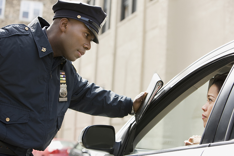 police officer leaning on car talking to driver