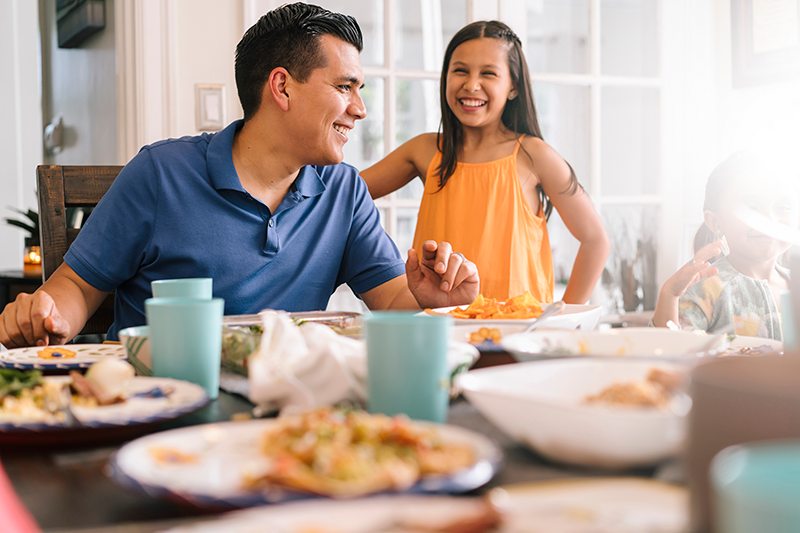 man and daughter at dinner table laughing