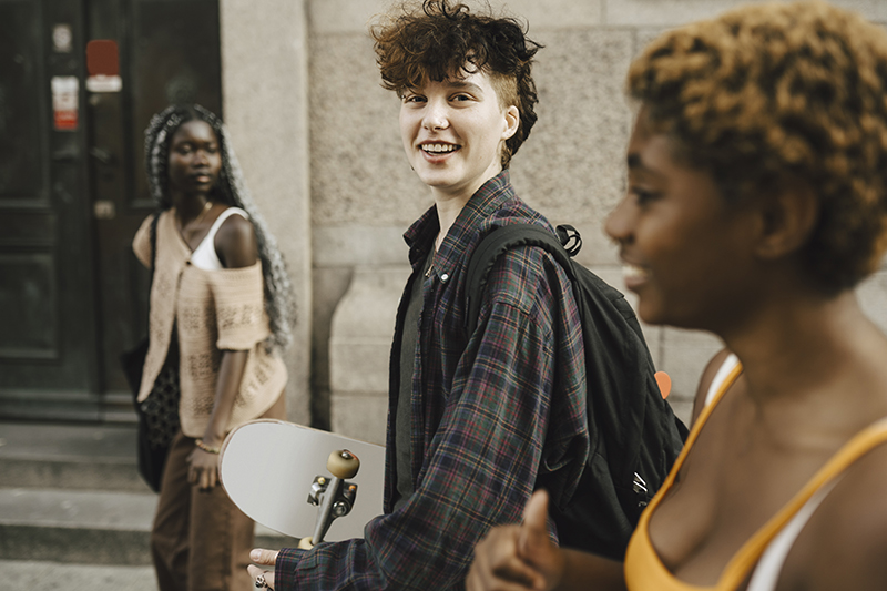 young persons walking down a street smiling