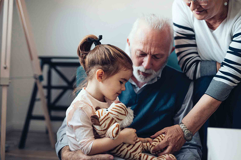 older couple looking down at little girl