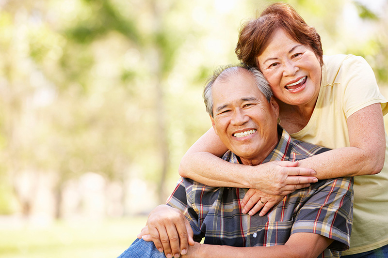 older couple hugging and smiling at the camera