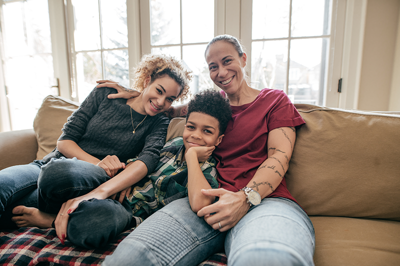 family sitting on couch smiling