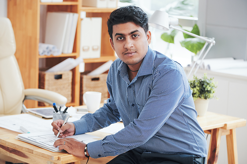 man at table with paperwork and pen