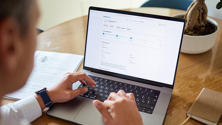 Person filling out an online application on a laptop